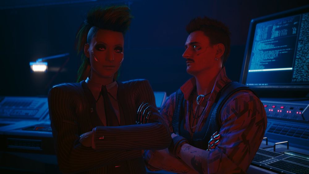 Fem V smirks at the camera with her arms crossed while an agent transfers data beside her.
