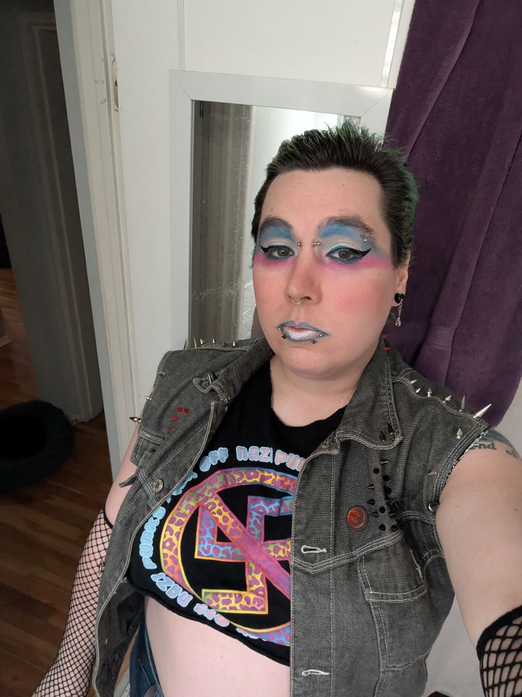 A pre concert punk selfie with a "Nazi punks fuck off" shirt and trans flag makeup and a spikey jacket and slicked back hair