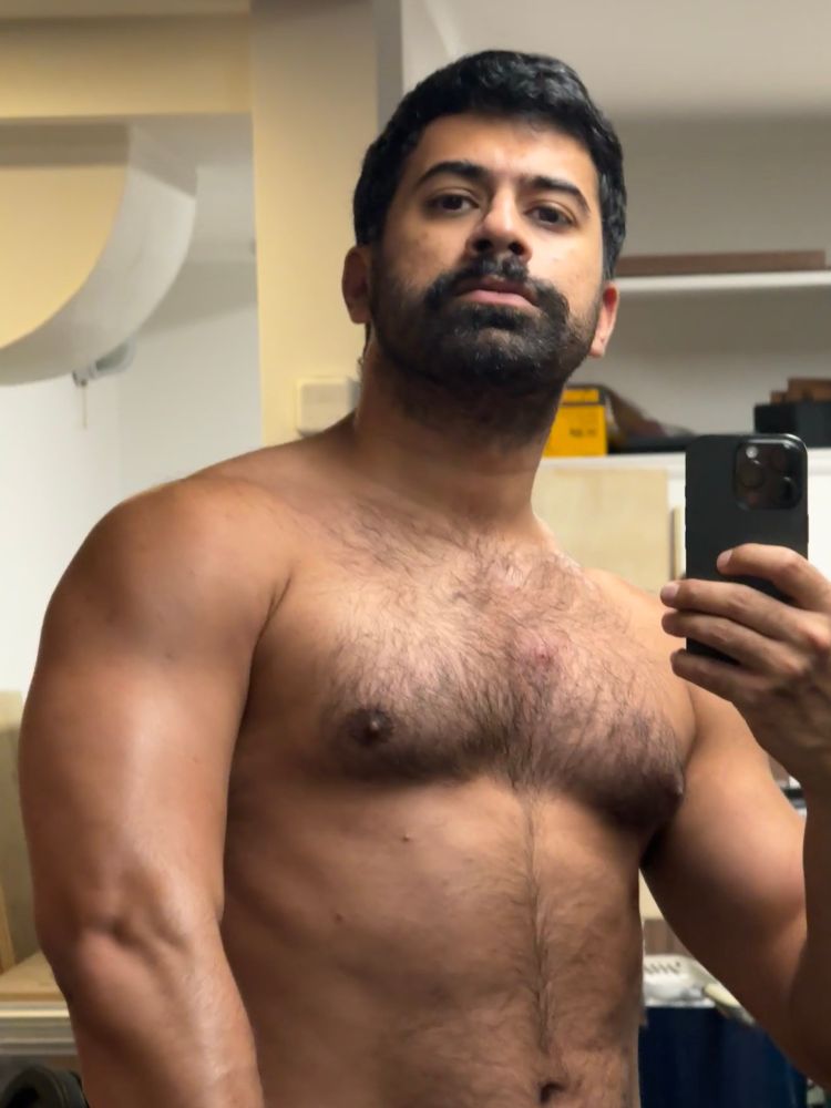 shirtless in front of the mirror, flexing my chest and left tricep