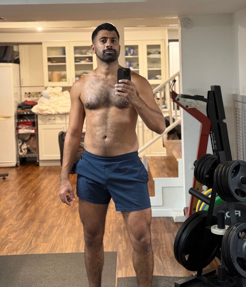 shirtless gym mirror pic wearing navy gymshark shorts. some weights plates are visible to my right 