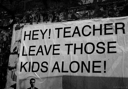 Lyrics of pink Floyd on a wall somewhere as a black and white photo. "Hey! Teacher leave those kids alone! (Caps lock)