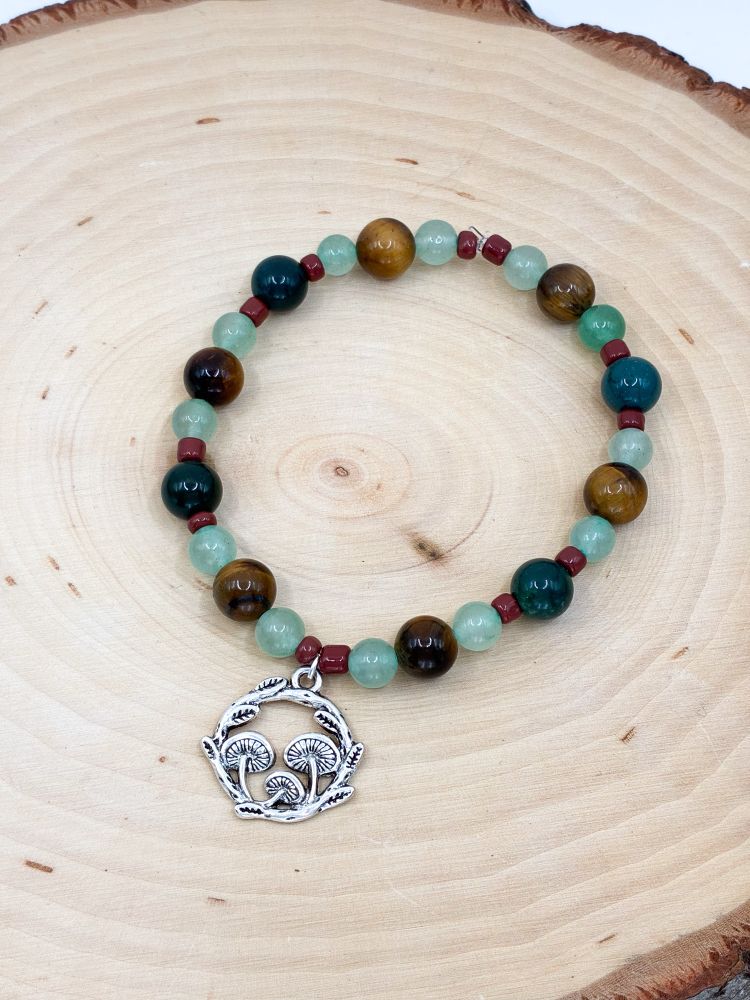 A bracelet I made with green aventurine, moss agate, and tigers eye beads and a mushroom charm 