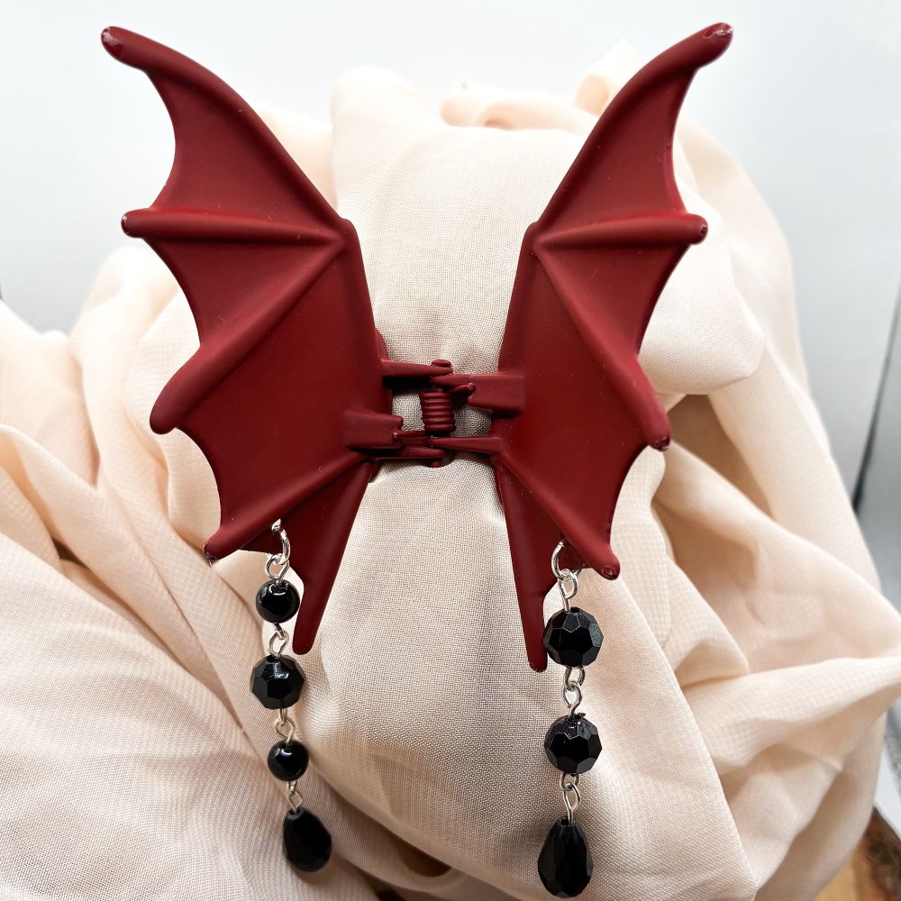 A red bat/dragon wing hair clip with black onyx beads