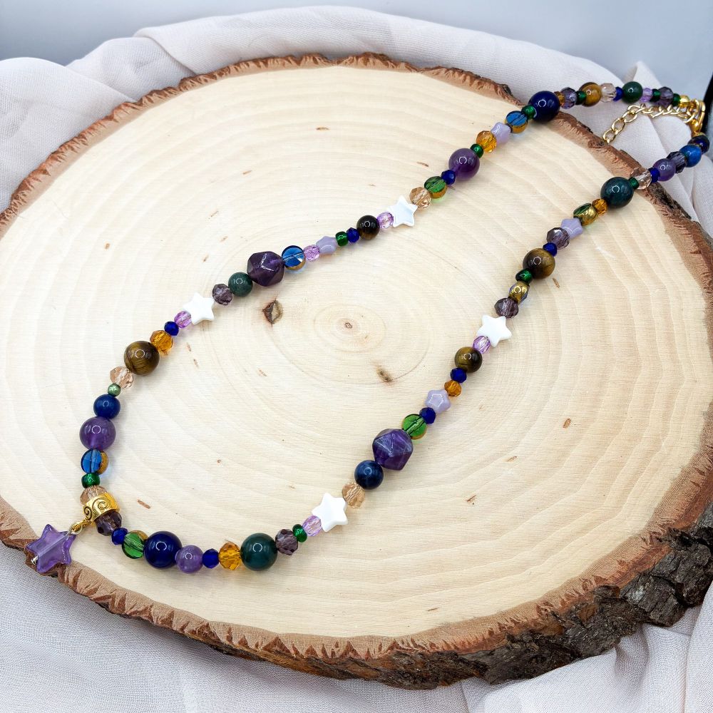 A necklace I made with purple, blue, brown, green, orange, and white beads. And an amethyst star pendant 