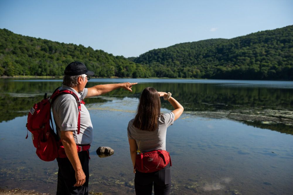 2 researchers pointing at body of water