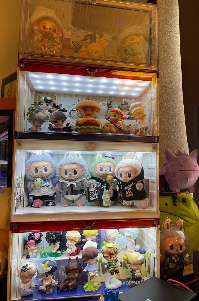A tower of official Pop Mart display cases (4) filled with Labubu, Dimoo, and Molly figurines and plush pendants.