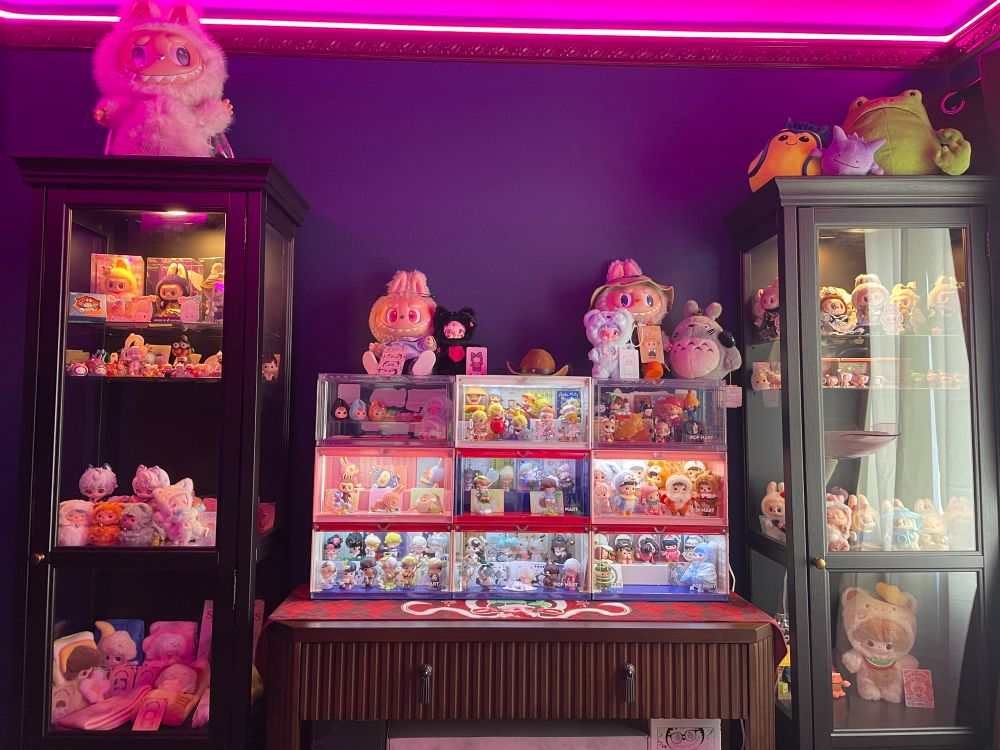 A wall lined with numerous display cases filled with Pop Mart collectibles and other blind box items. 