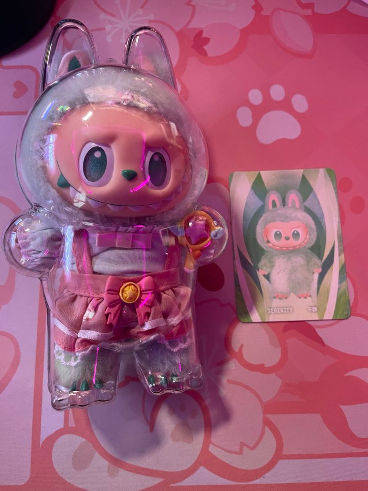 Labubu Big Into Energy version 3! I pulled the green one, Serenity! I dressed her up as a magical girl! Labubu v.3 in a magical girl outfit in a protective case next to her character card.
