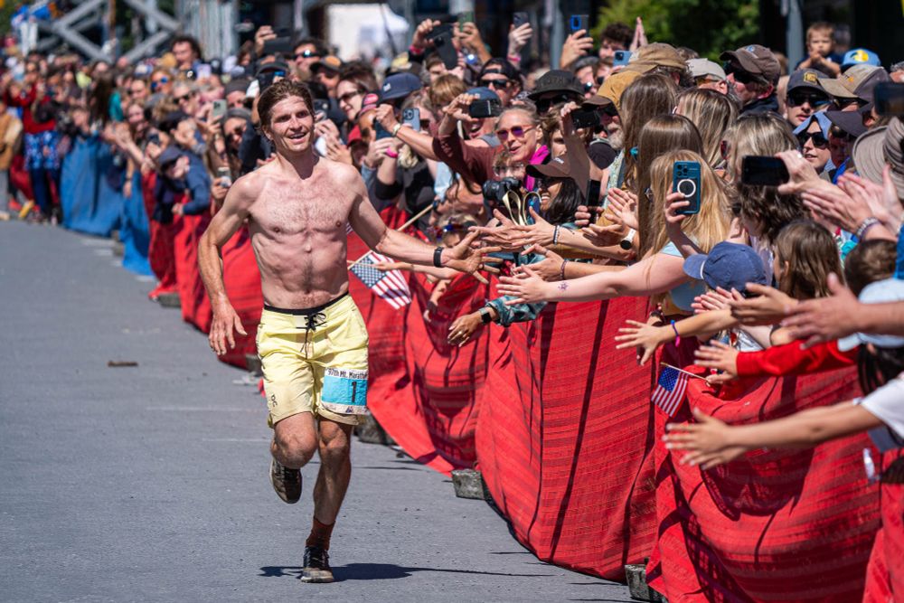 David Norris greets fans as he runs down 4th Avenue during the 97th running of the Mount Marathon Race on Friday, July 4, 2025 in Seward. Norris won his 6th Mount Marathon Race this year.