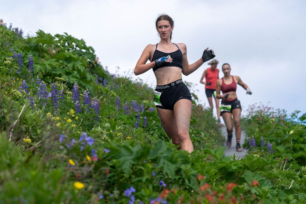 Mya Taylor makes her way through a field of wildflowers during the 97th running of the Mount Marathon Race on Friday, July 4, 2025 in Seward.