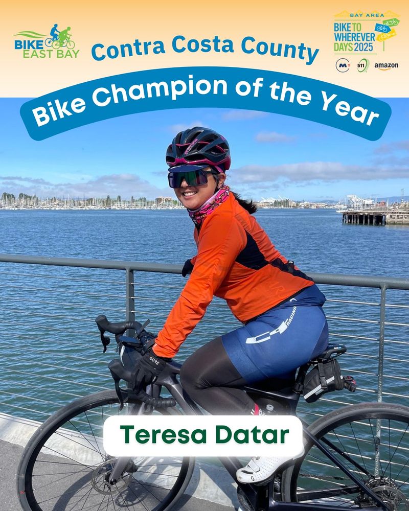 Teresa Datar of Contra Costa County sits on her sleek black bike, wearing a helmet, sunglasses and bike gear with a beautiful waterfront view behind her.