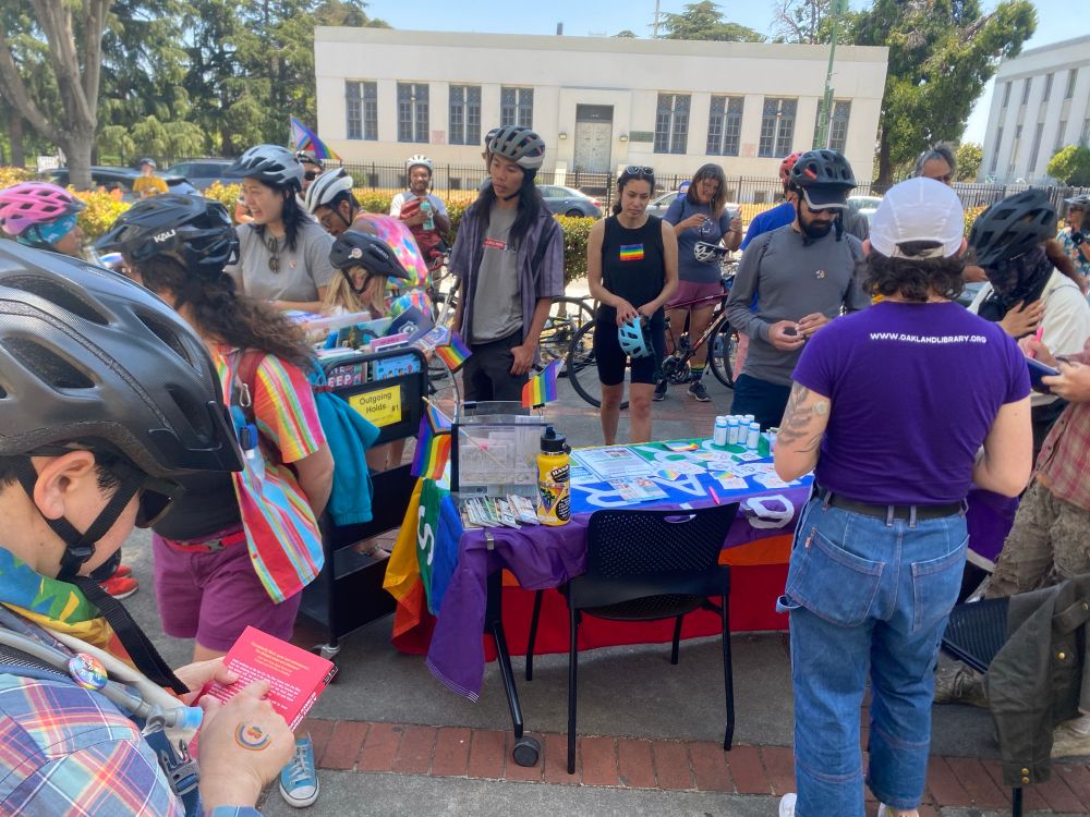 We love books! We detoured to check out the Main Branch’s LGBTQ+ collection and renew our library cards. A crowd of helmet-clad people see what the Library has to offer at their outdoor booth. 