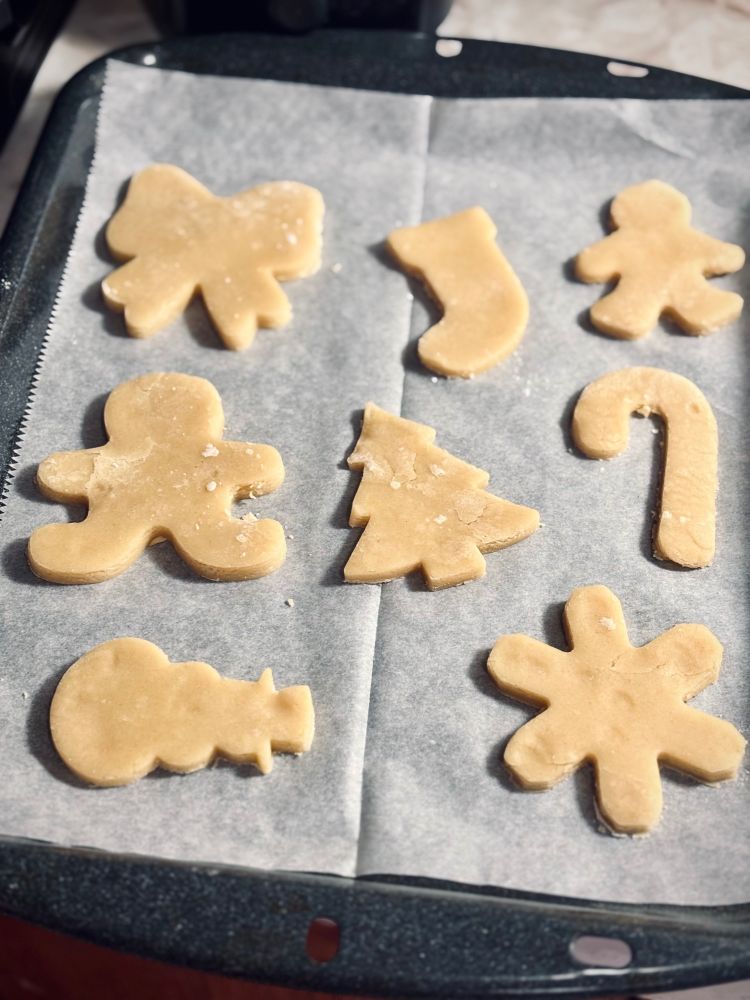 sugar cookie dough cutouts on a pan ready to bake.