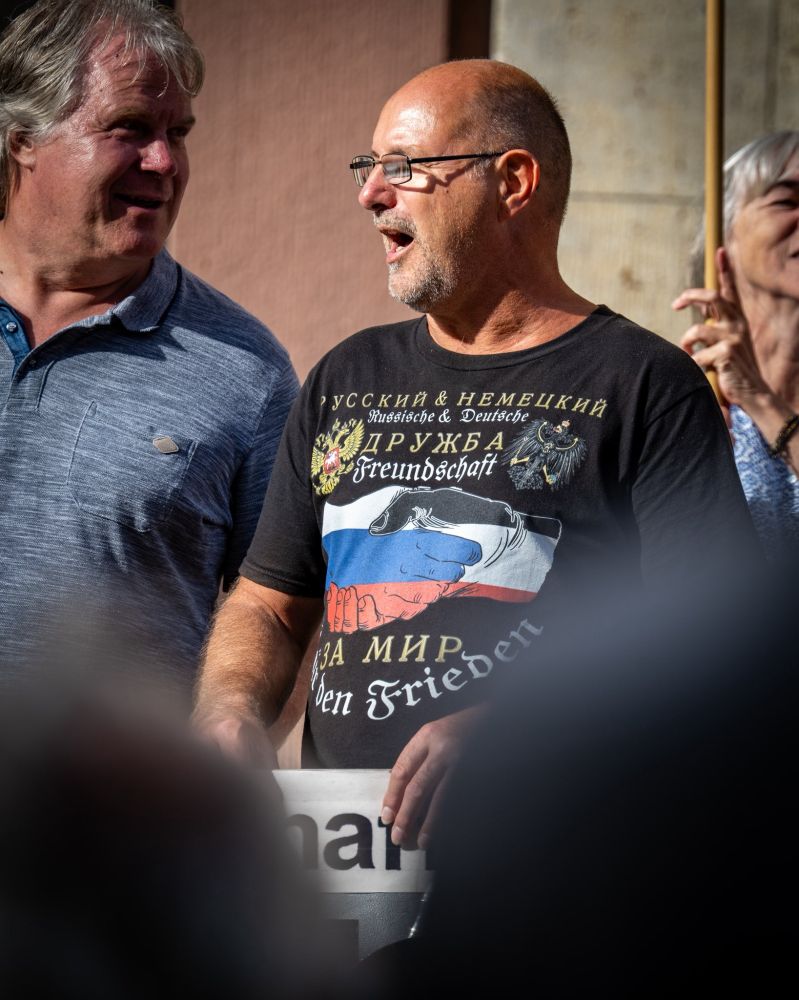 Zwei ältere Teilnehmer. Eine trägt ein Shirt, auf dem sich zwei Hände 