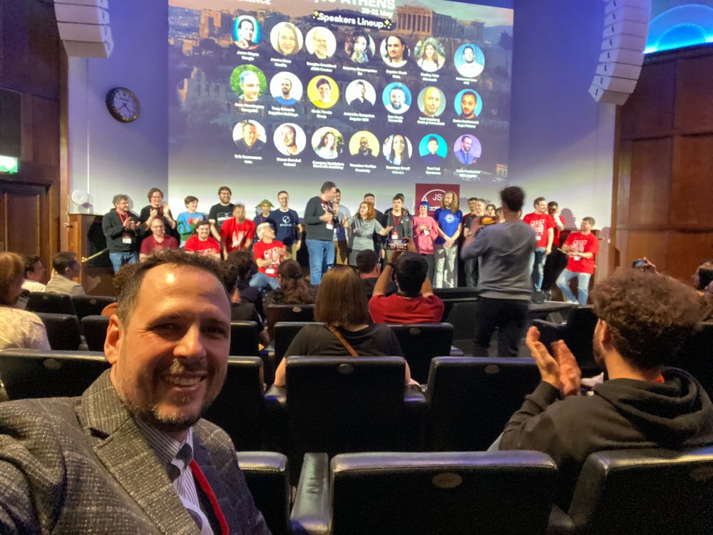 Ricardo in the seats in front of the organisers and speakers of the conference gathering on stage