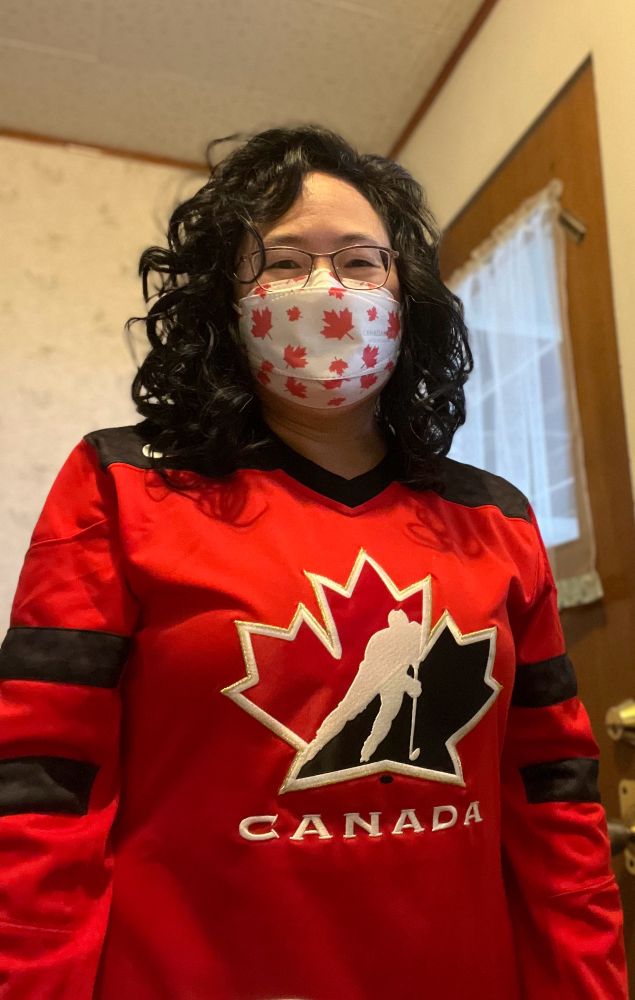 Photo of me wearing a Canada hockey jersey with a Canada Maple-leaf imprinted mask. 