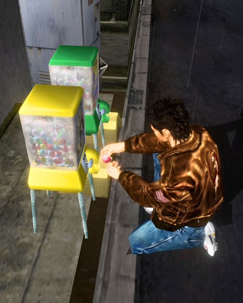 A screenshot from Shenmue showing Ryo Hazuki kneeling in front of a pair of capsule toy machines.