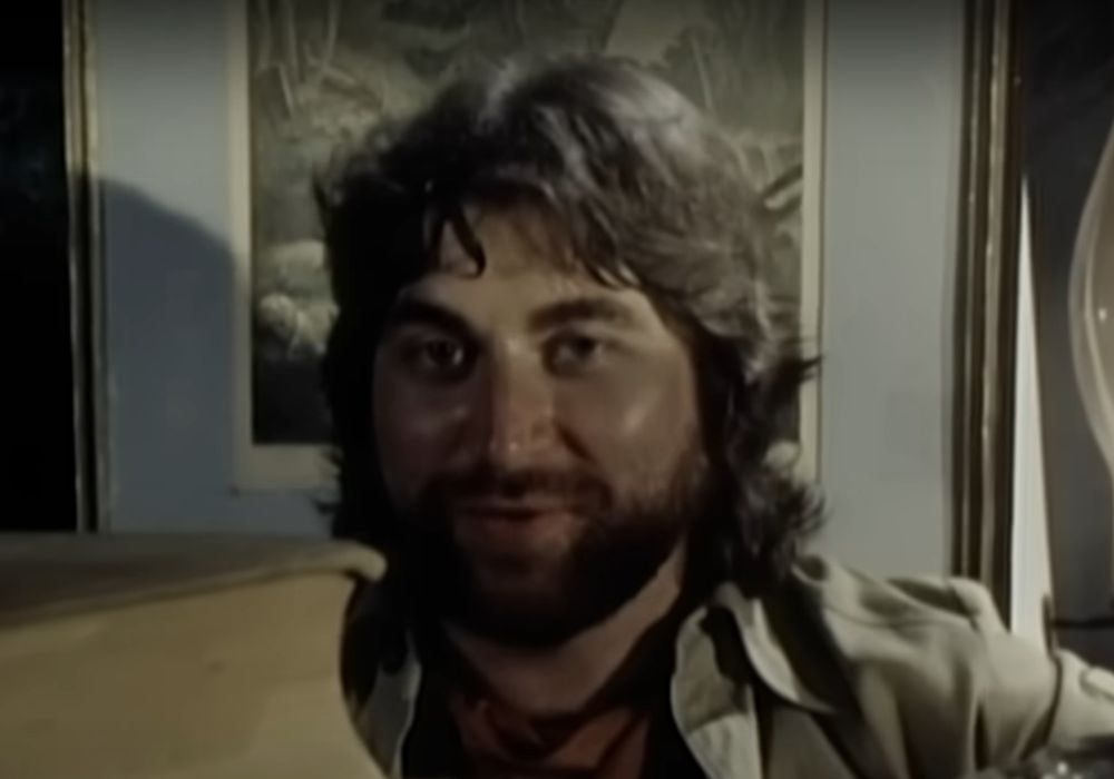 In a shot from the 1982 official video for Toto's hit "Africa", Dave Paich -- wearing a shirt with a vague explorer vibe that was definitely not viewed as problematic during the video's shoot -- stares deep into your eyes with a sly smile that indicates he knows that he has you. You will never be able to avoid singing along to this song for the rest of your life. Even if you're not a Toto fan or hate Yacht Rock, you're trapped. You'll never forget one word of this masterpiece. You will spend the rest of your days blessing the rains down in Africa. 