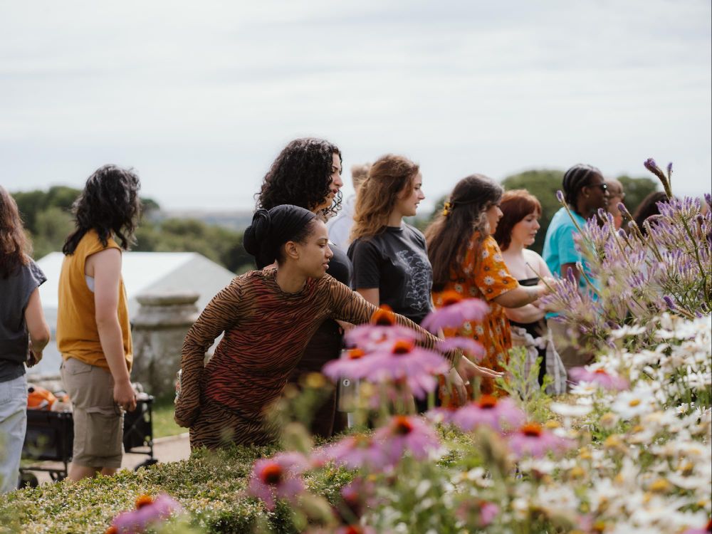 Youth Panel members are pointing and look at a colourful flower border.