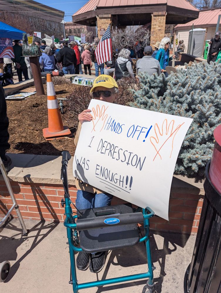 Protestor with sign, Hands off, 1 Depression was enough 