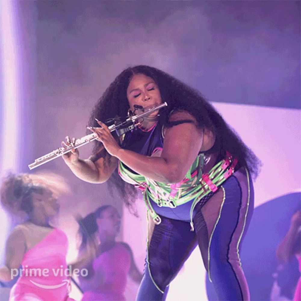 a woman playing a flute in front of a sign that says prime video on it