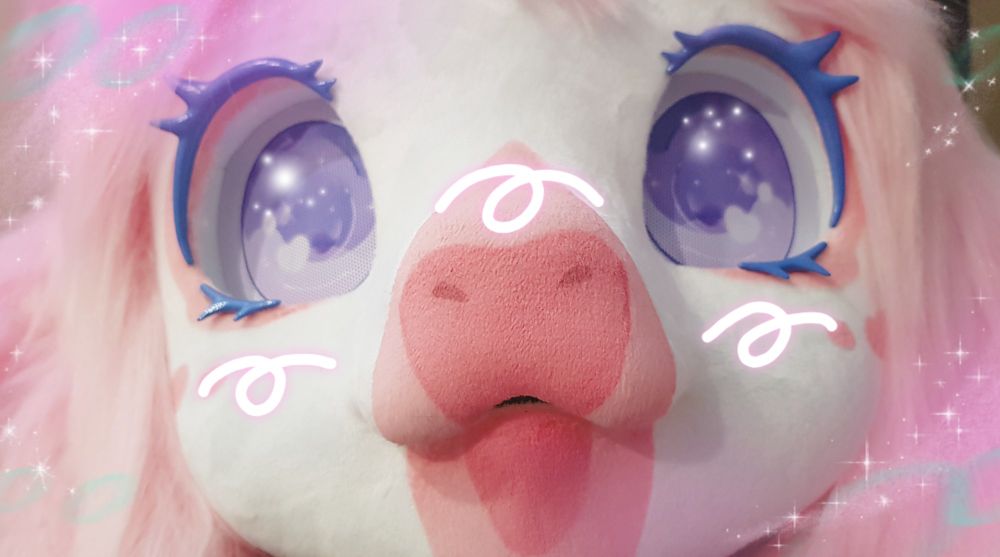 A close up of a pink cow fursuit, looking up like a small child