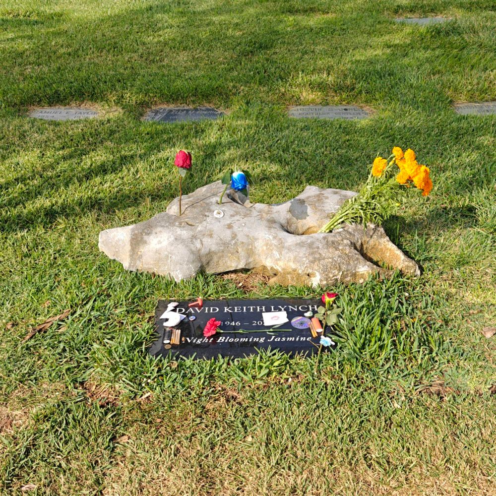 A red and blue rose are placed in some of the holes, and a bunch of yellow flowers too.