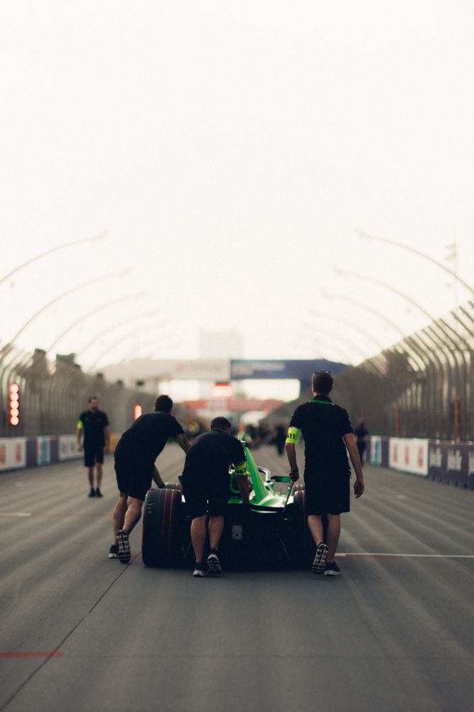 Three mechanics push the Envision Racing Jaguar I-Type 7 to the grid for a pre-season photoshoot. 