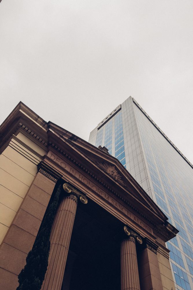 An old church is photographed beside a new modern skyscraper. 