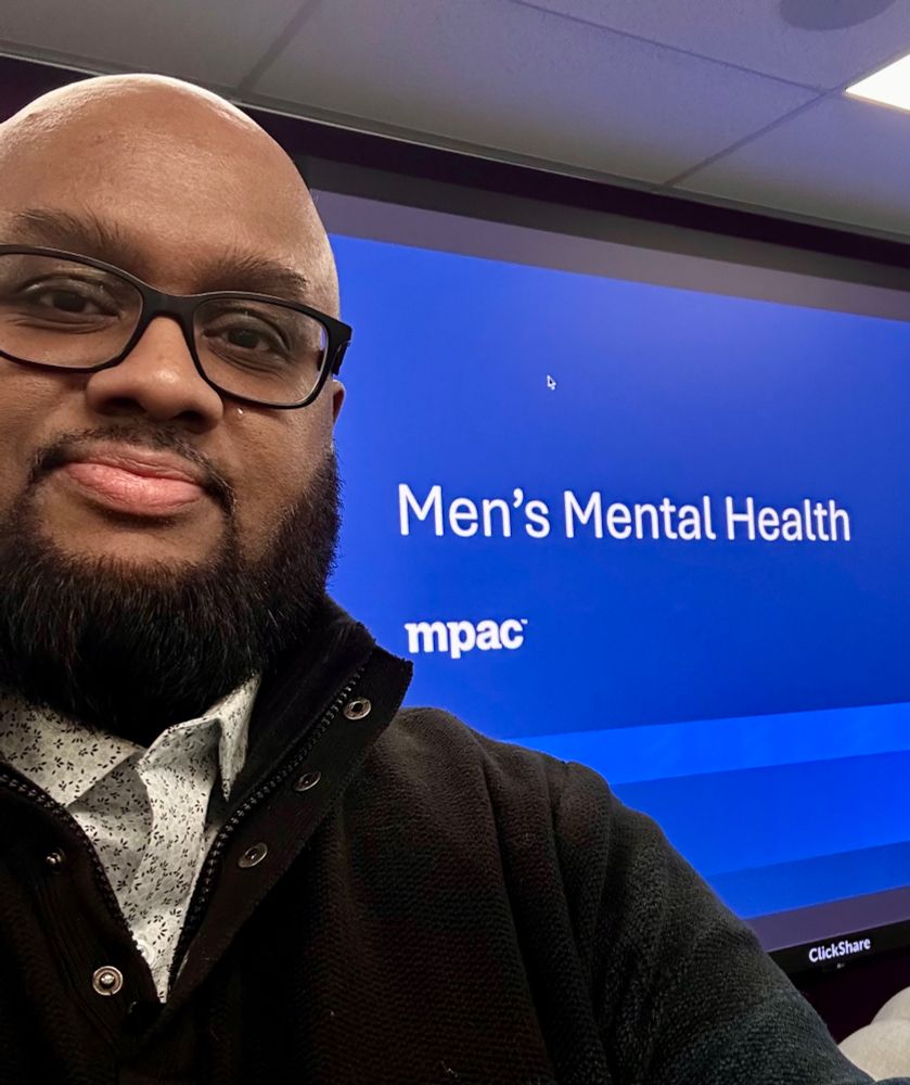Jeff standing in front of the Men’s Mental Health title for a panel at MPAC 
