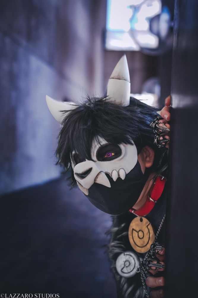 Shibalove Cosplay as King peaks out from a pillar, looking calmly at something in the distance 