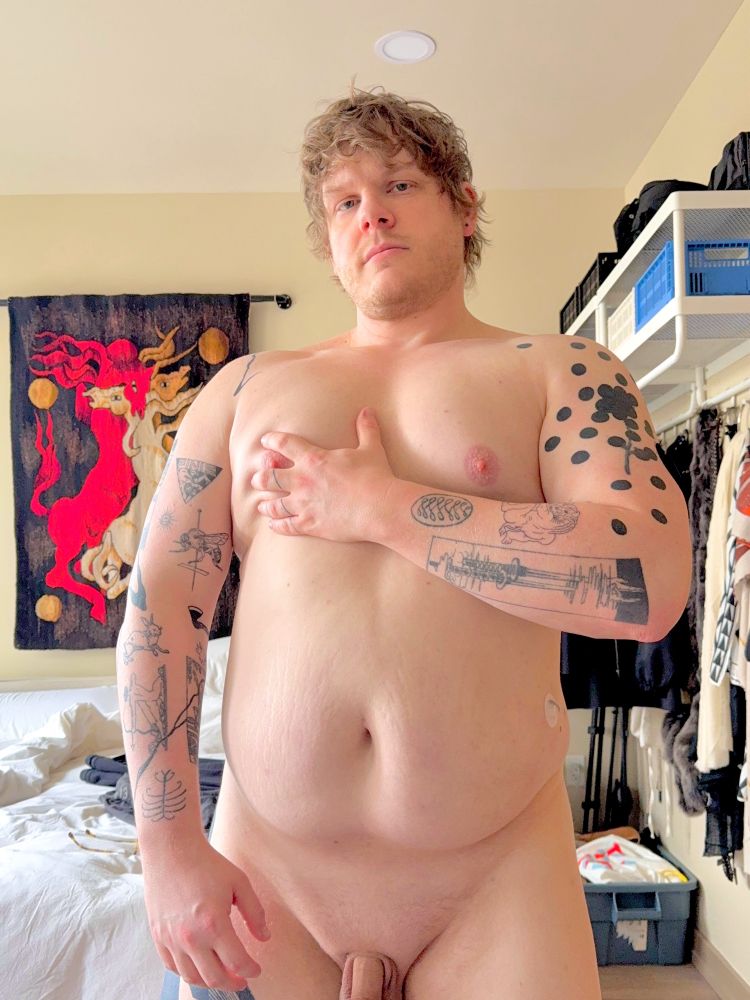 Me, standing nude in my bedroom, grabbing my chest.