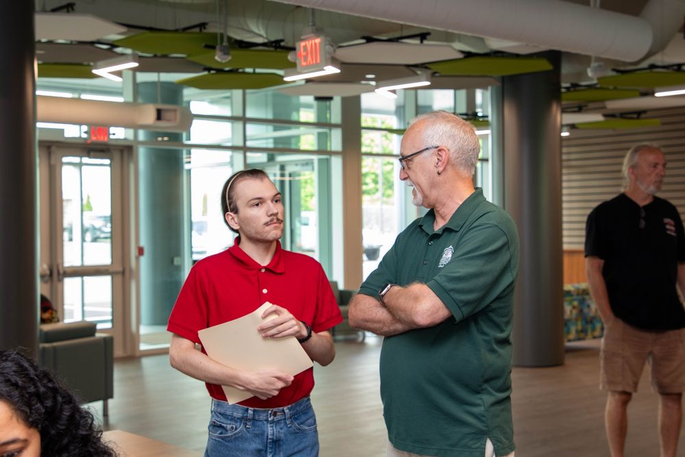 Job seekers interacting with representatives at employer and vendor tables