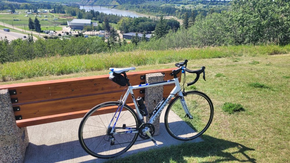 my bike leaning against a bench on the top edge of a hill overlooking the Whitemud Equestrian Park -- freeway on the left of it, North Saskatchewan River on the right