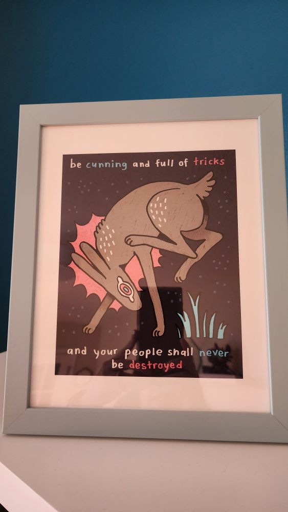 Framed art from watership down that says "be cunning and full of tricks and your people shall never be destroyed" with a pastel blue frame