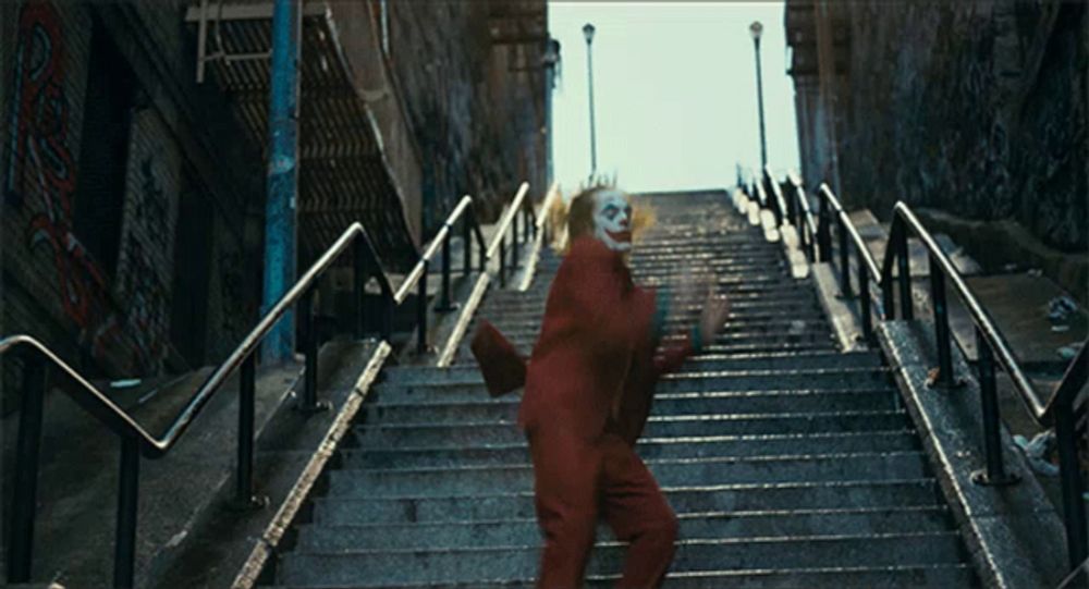 a man in a clown costume is standing on a set of stairs