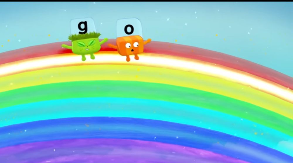 Alphablock G (green block with grass with the letter “g”) and Alphablock O (orange block with letter “o) are dancing on a rainbow, and they’re on the orange bar.