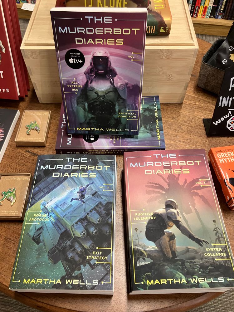 A display table with copies of all three volumes of the Murderbot diaries paperback collected editions 