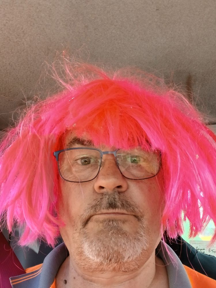 Old man with glasses wearing a pink wig
