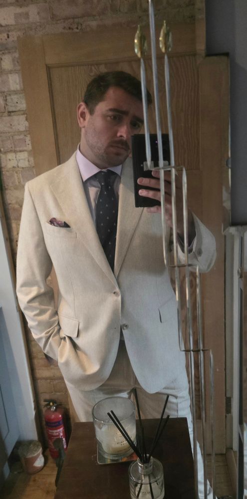 A man in a very pale cream grey suit
