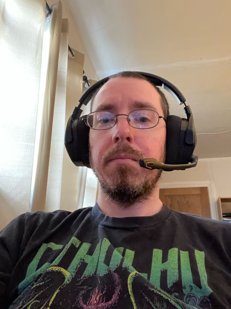 Me with my headset, wearing my Cthulu Respects Pronouns shirt