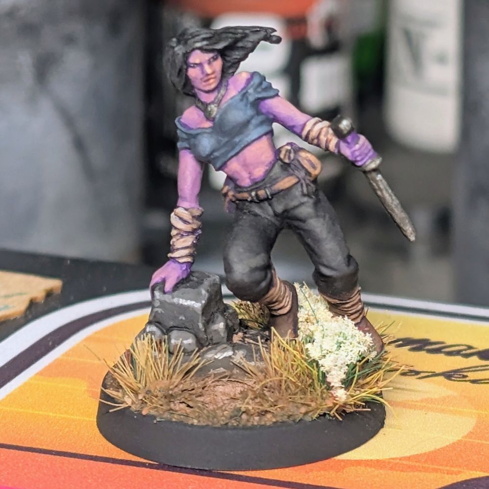 A miniature of a woman with a knife jumping over something. 