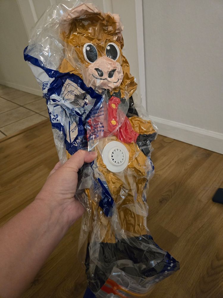A very squished highland coo plushie