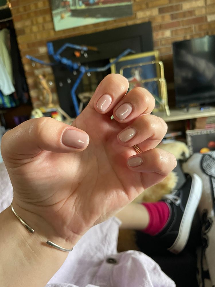 A white persons hand showing short manicured natural colored nails