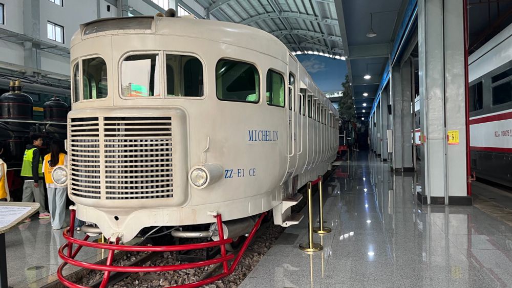 old white rubber tired metre gauge train in a railway museum hall