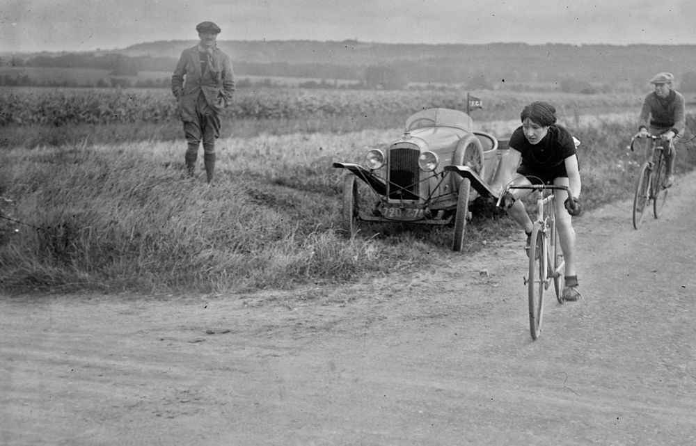 B+W photo. Mlle Brunet taking part in the 1927 national championships organised by the FFSF. She's approaching a turn and is being followed by a spectator on a bike.