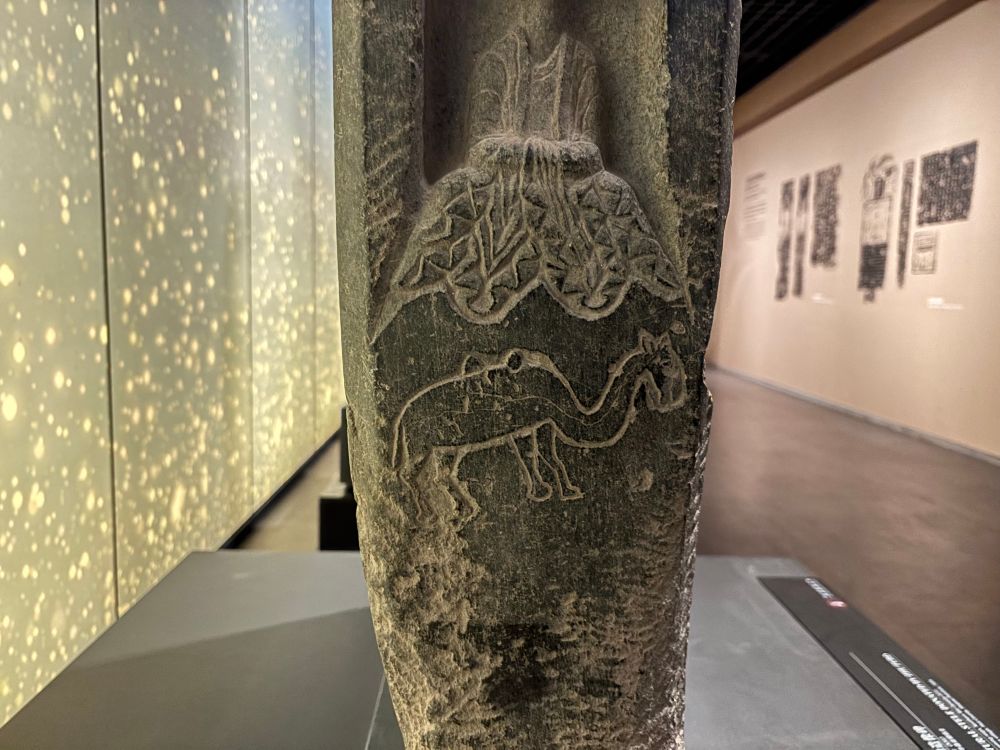 View of the edge of a stone stele with a sweetly wonky little camel.