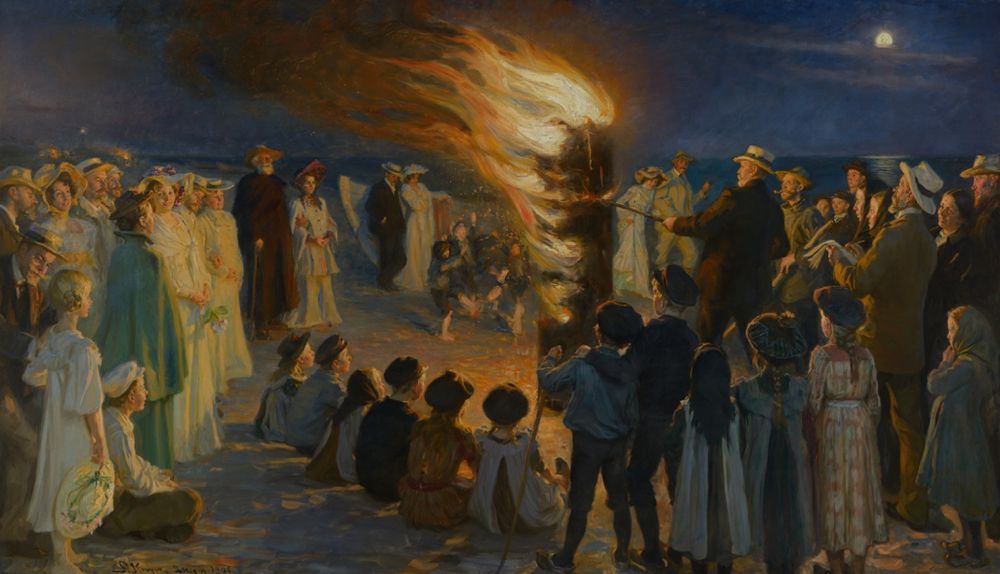 Midsummer bonfire in the evening with crowd of people