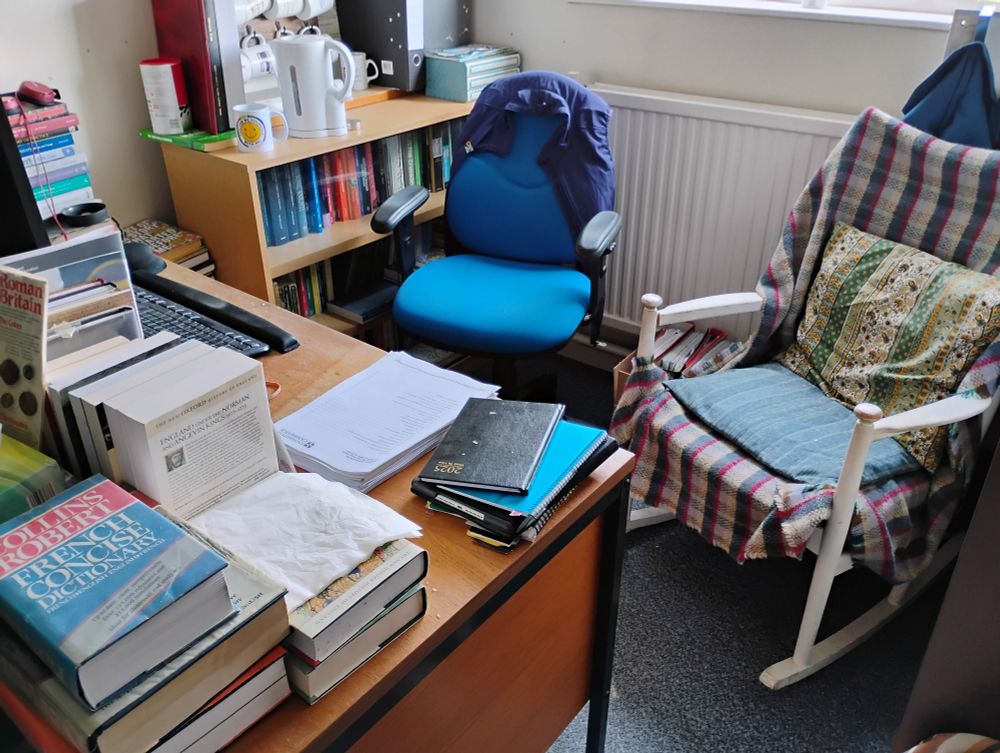 Office with desk, bookshelves, desk chair and rocking chair.
