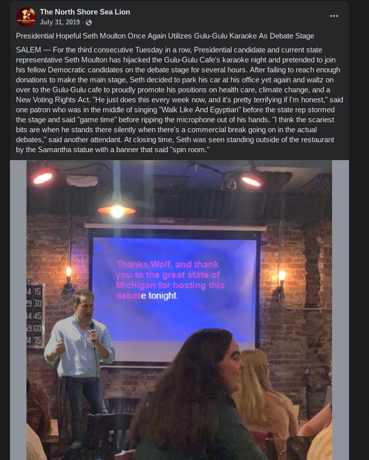 A photoshop of Seth Moulton before a screen at the Gulu-Gulu Cafe and the following text: "Presidential Hopeful Seth Moulton Once Again Utilizes Gulu-Gulu Karaoke As Debate Stage
SALEM — For the third consecutive Tuesday in a row, Presidential candidate and current state representative Seth Moulton has hijacked the Gulu-Gulu Cafe's karaoke night and pretended to join his fellow Democratic candidates on the debate stage for several hours. After failing to reach enough donations to make the main stage, Seth decided to park his car at his office yet again and waltz on over to the Gulu-Gulu cafe to proudly promote his positions on health care, climate change, and a New Voting Rights Act. "He just does this every week now, and it's pretty terrifying if I'm honest," said one patron who was in the middle of singing "Walk Like And Egyptian" before the state rep stormed the stage and said "game time" before ripping the microphone out of his hands. "I think the scariest bits are when he stands there silently when there's a commercial break going on in the actual debates," said another attendant. At closing time, Seth was seen standing outside of the restaurant by the Samantha statue with a banner that said "spin room.""